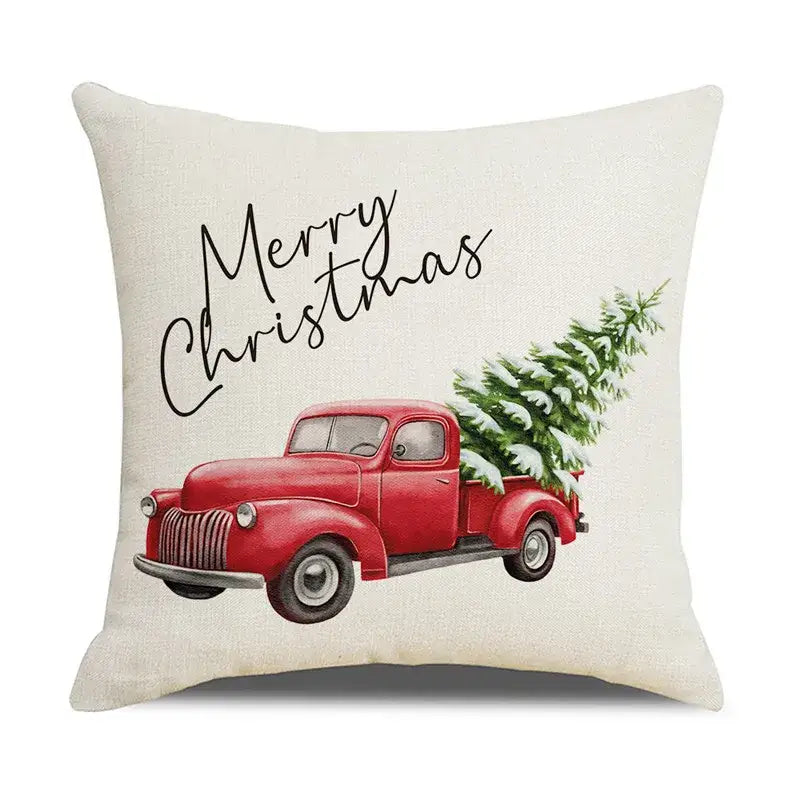 Cream-colored linen pillow cover with vintage red truck carrying snow-dusted tree and merry christmas script decorbites christmas snow