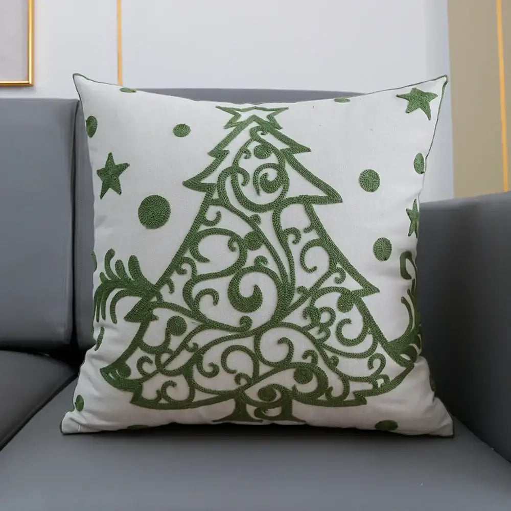 White cushion cover with ornate green embroidered christmas tree featuring stars and dots from decorbites christmas snowflake collection