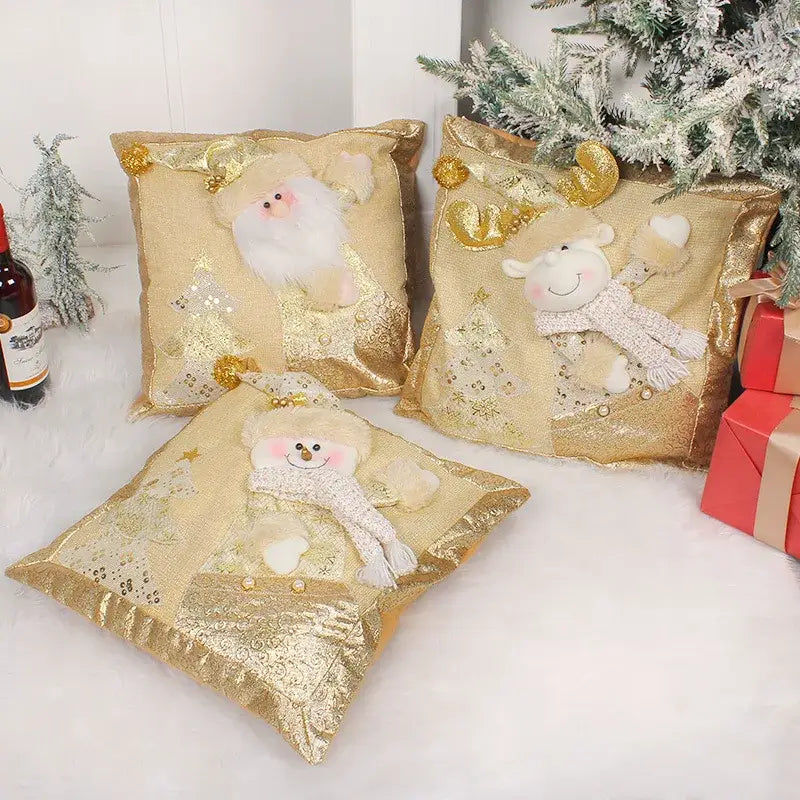 Three festive gold embroidered pillowcases featuring santa claus snowman and reindeer plush characters with sequined trees