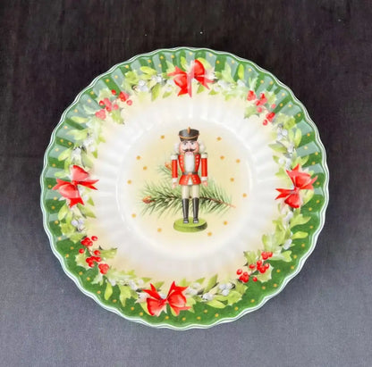A festive ceramic plate from DecorBites Christmas tableware featuring a nutcracker and holly design on its rim