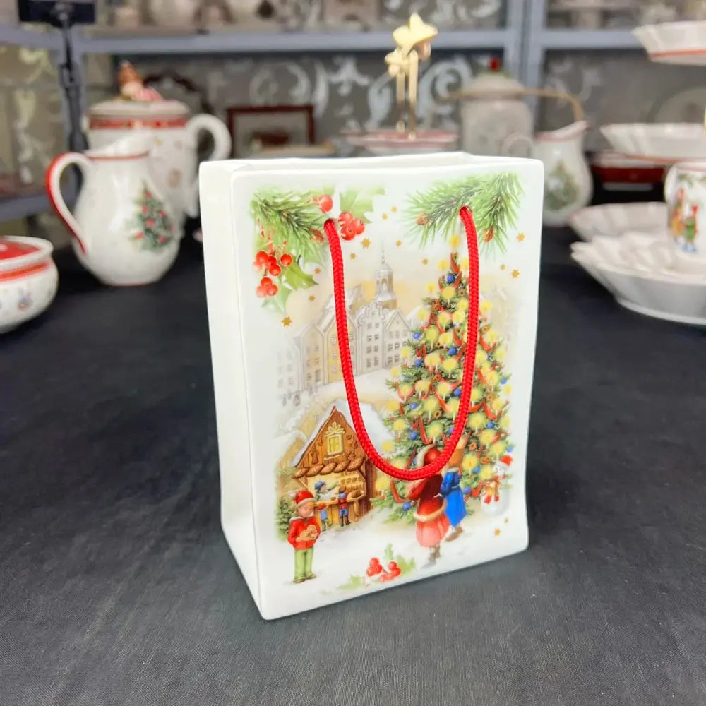 White ceramic gift bag with red handles and festive holiday illustrations from DecorBites Christmas tableware set