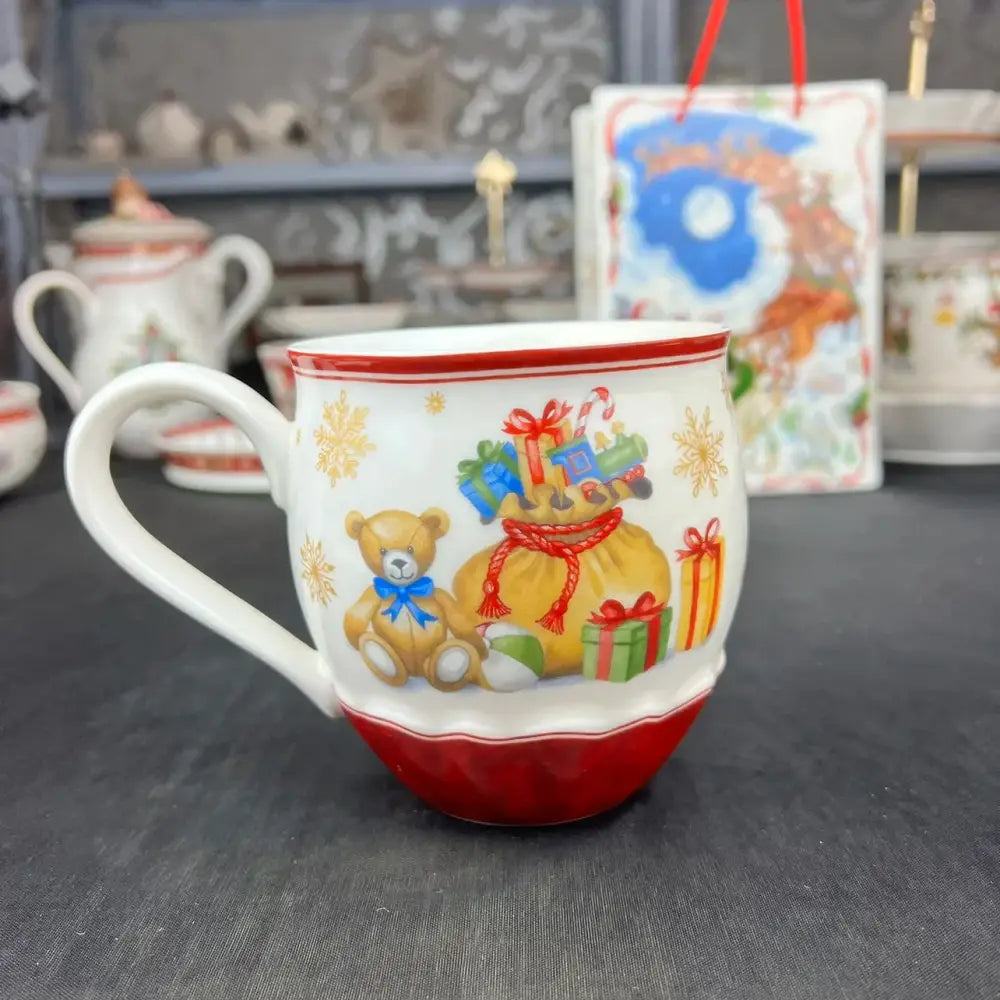 White ceramic mug with red rim featuring festive teddy bear and gifts from decorbites christmas tableware set