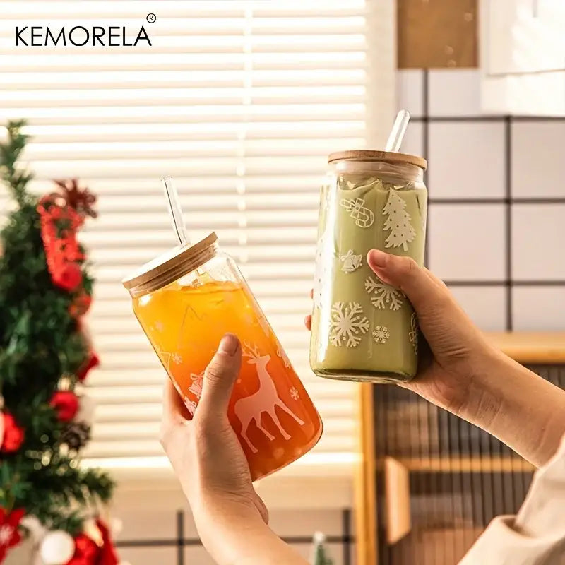 Two festive decorbites christmas glass beer can mugs with wooden lids and straws decorated with reindeer and snowflakes