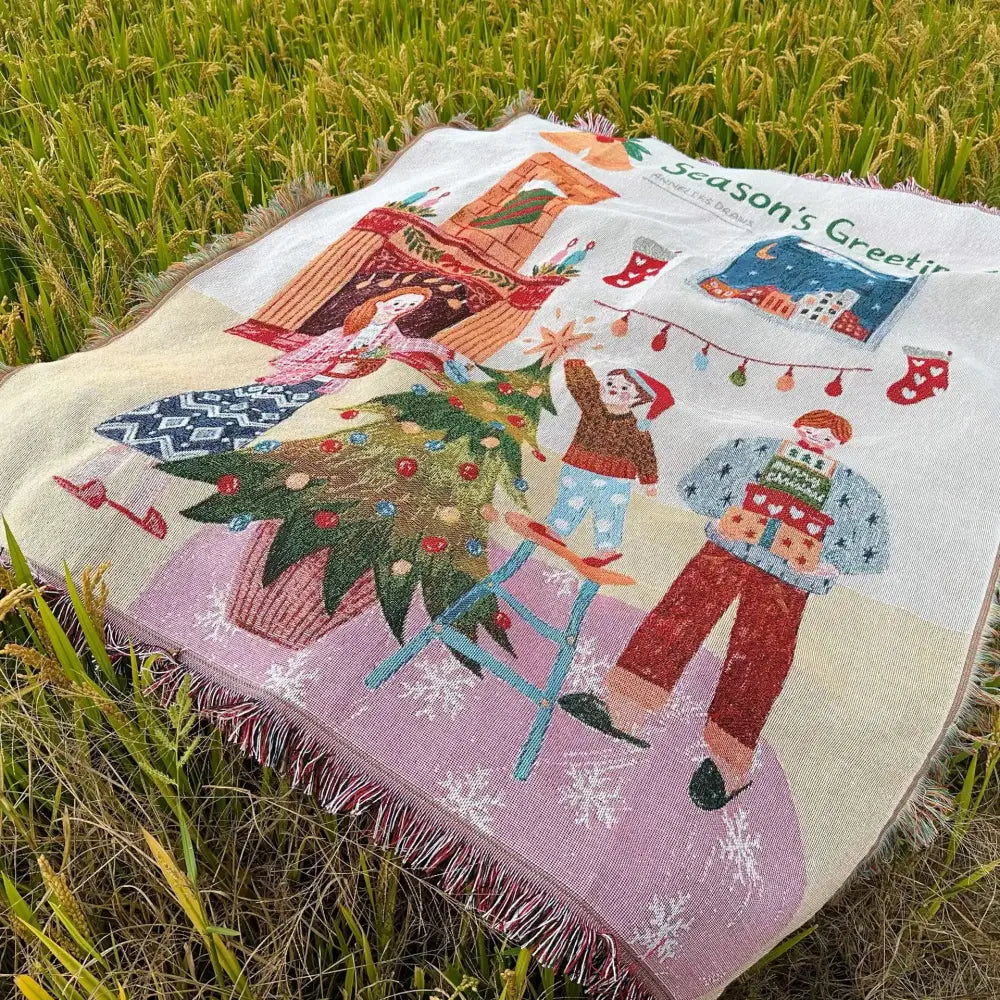 A cozy cream-colored woven decorbites christmas tree blanket throw with festive children decorating a tree scene