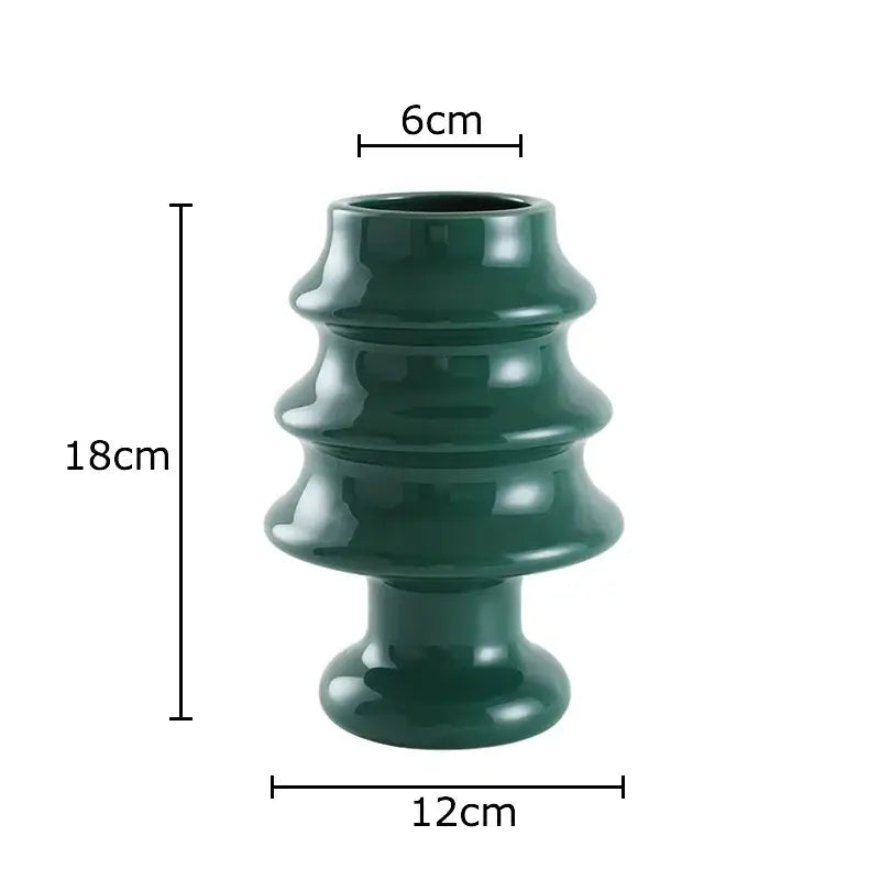 A sleek dark green ceramic vase with tiered design from decorbites christmas tree collection for holiday room decor