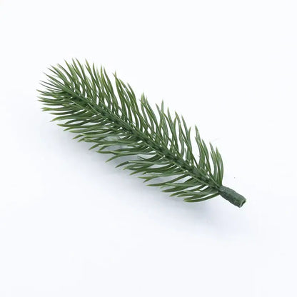 A synthetic green pine branch with detailed needle-like foliage and textured stem for decorbites christmas tree decor