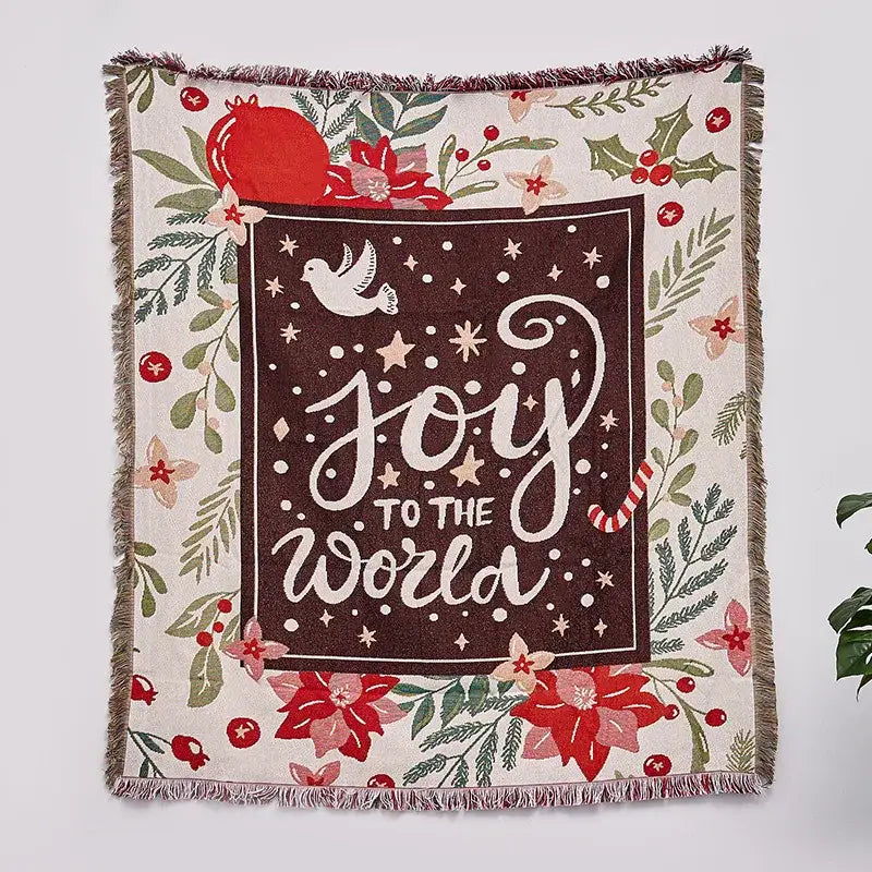 A decorbites christmas tree knitted throw blanket in cream with a dark brown joy to the world panel and festive red poinsettias