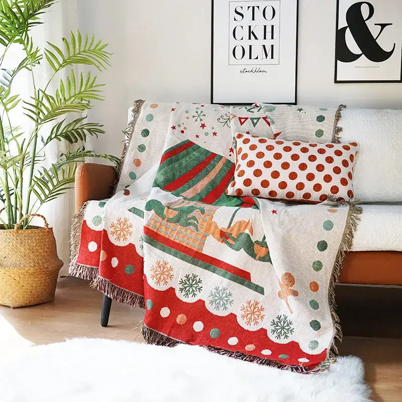 A decorbites christmas tree knitted throw blanket with red green and white holiday patterns draped over a sofa