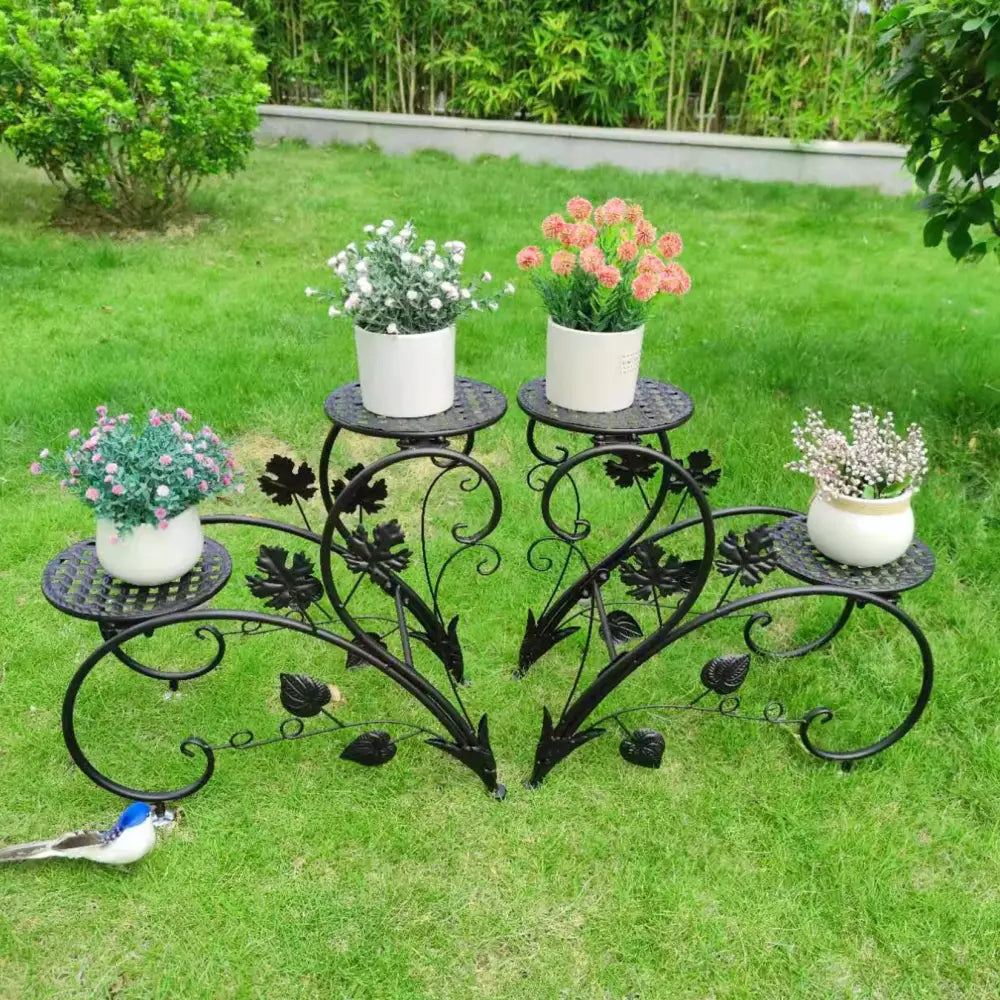 Black wrought iron classic tall plant stand with ornate leaf designs featuring three white ceramic pots for indoor outdoor use