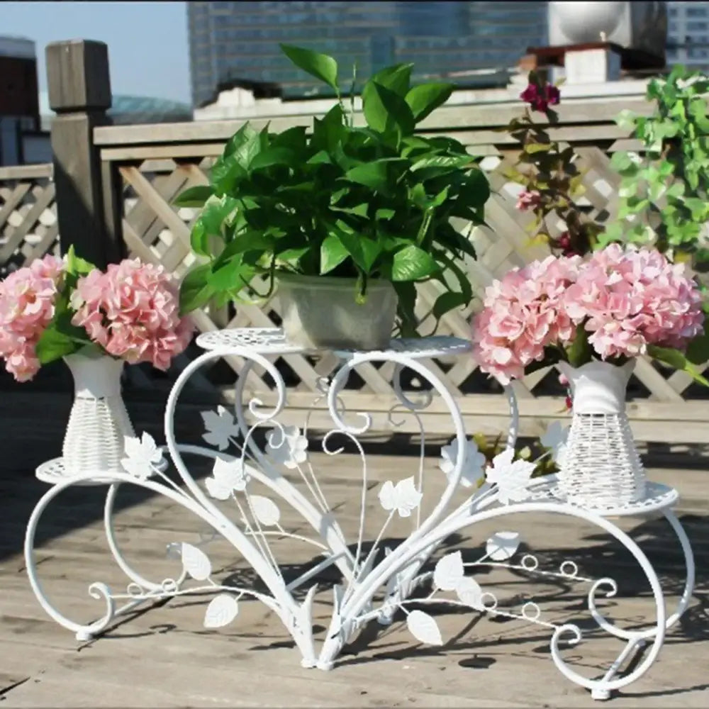 White wrought iron classic tall plant stand with leaf and vine scrollwork for indoor and outdoor use