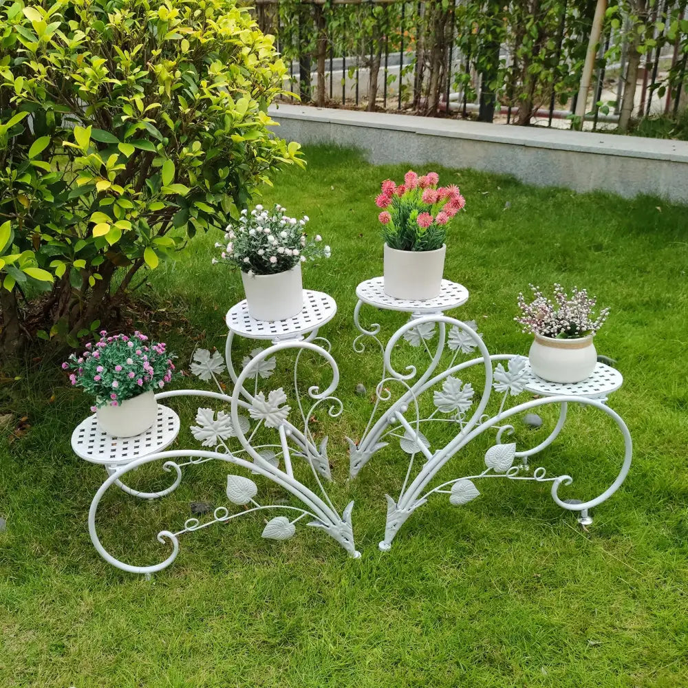 White wrought iron DecorBites classic tall plant stand with leaf vine scrollwork and three perforated platforms for indoor outdoor use