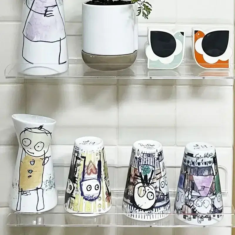 Decorbites™ clear acrylic wall mounted shelf organizer holding whimsical white ceramic vases with colorful illustrations