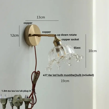 Brass wall lamp with decorbites clear flower glass shade and dangling crystal droplets for bedroom use