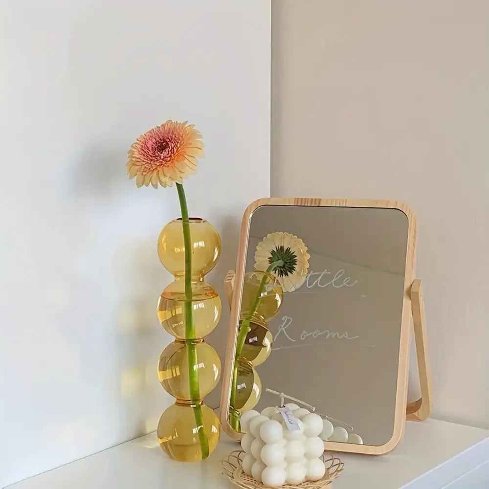 DecorBites™ clear glass bubble vase in amber with stacked spheres holds a pink and yellow gerbera daisy for home decor