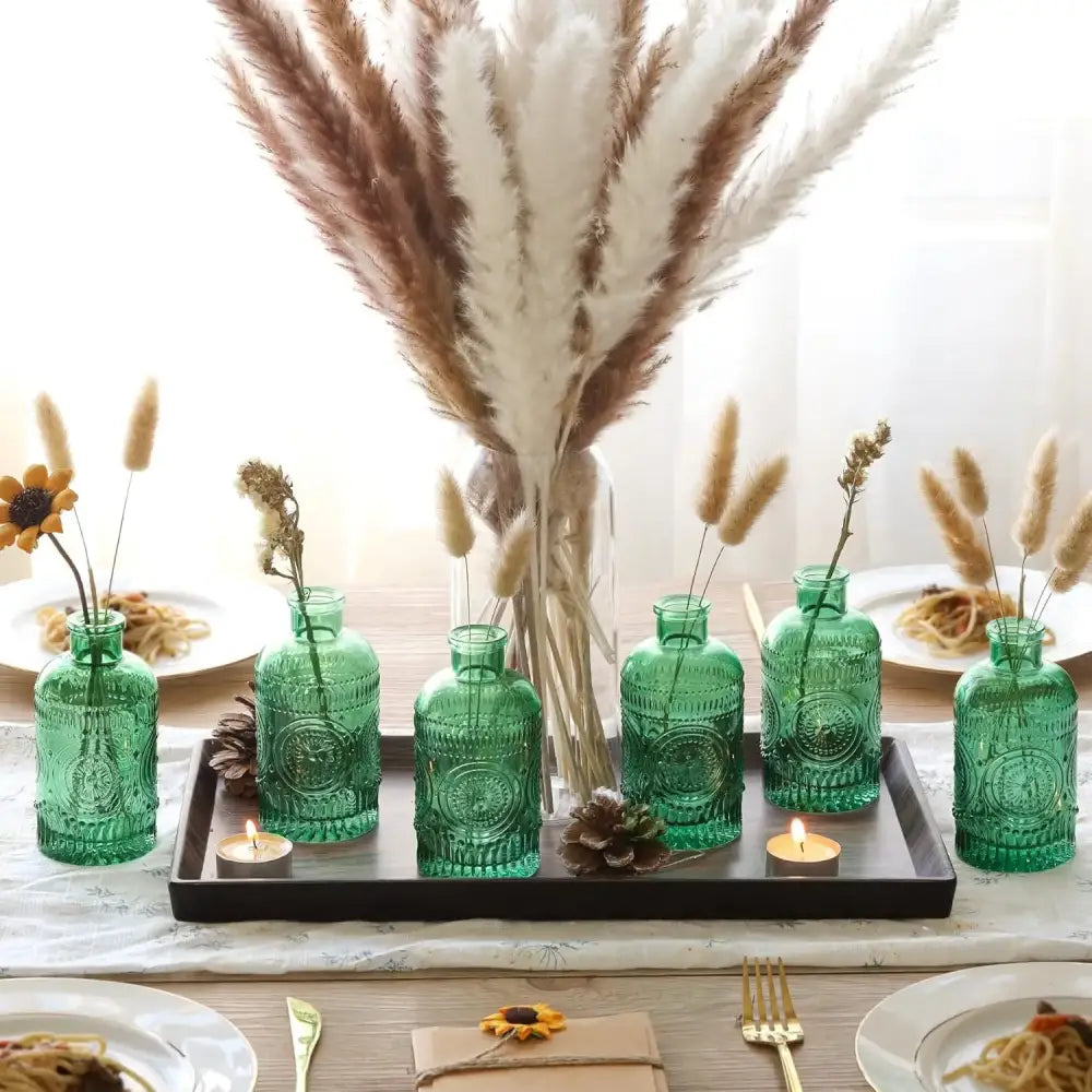 Set of six emerald green clear glass bud vases with embossed circular patterns on a dark tray from DecorBites™