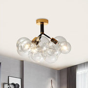 Decorbites™ semi flush ceiling light featuring clear glass bubbles with brass accents and black structural arms for foyer use