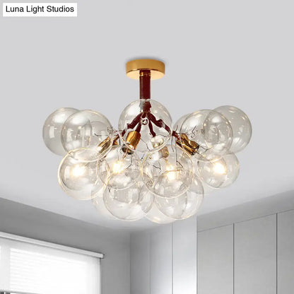 Modern glass bubble semi flush ceiling light with brass accents and exposed filament bulbs for foyer illumination