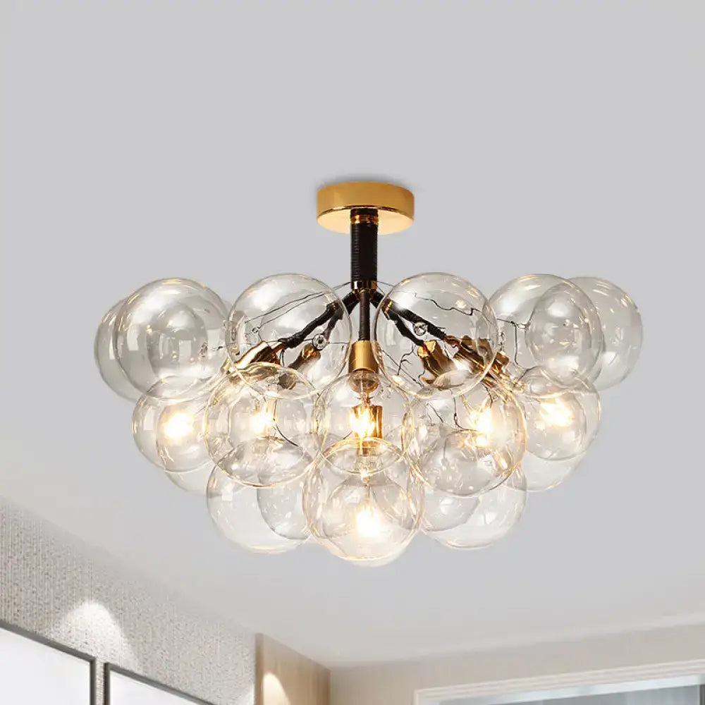 Gold-toned decorbites™ semi flush ceiling light with clear glass globes in contemporary bubble design for foyer illumination