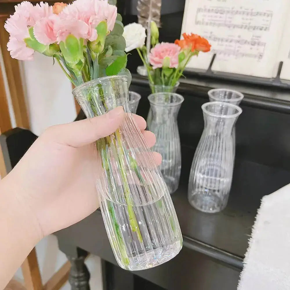Clear nordic plastic vase with vertical ridges holding pink carnations for hydroponic flowers by DecorBites