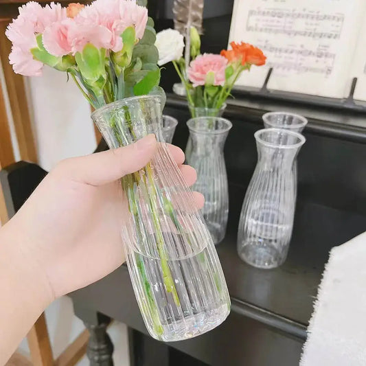 Clear nordic plastic vase with vertical ridges holding pink carnations for hydroponic flowers by DecorBites