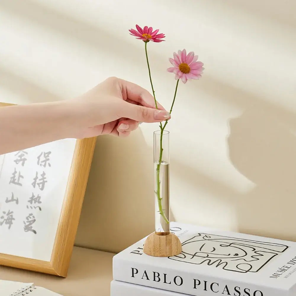 Decorbites clear plastic test tube vase with wooden base holding two pink daisies for home decor