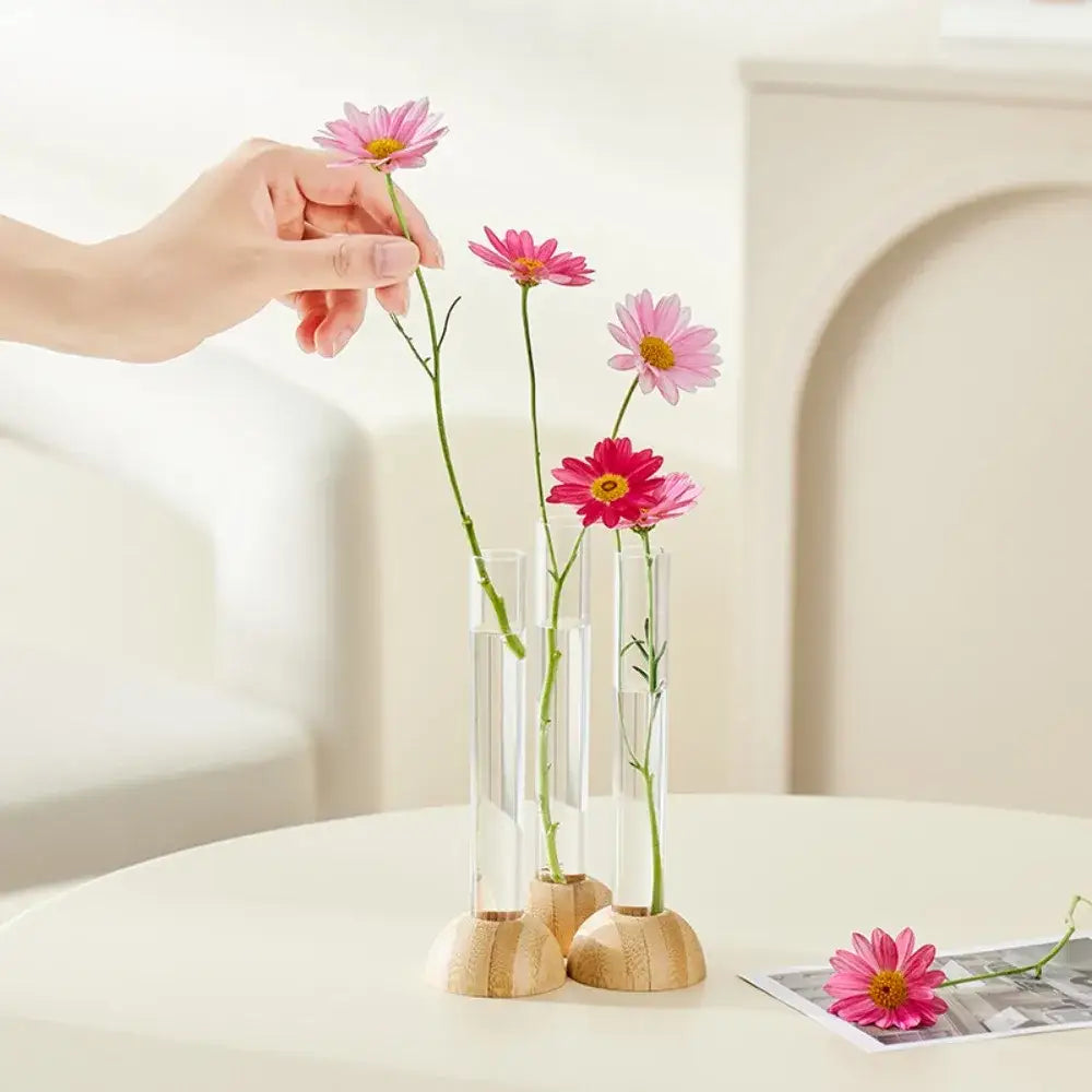 Decorbites™ clear plastic test tube vases with wooden bases hold pink daisies for elegant home decor