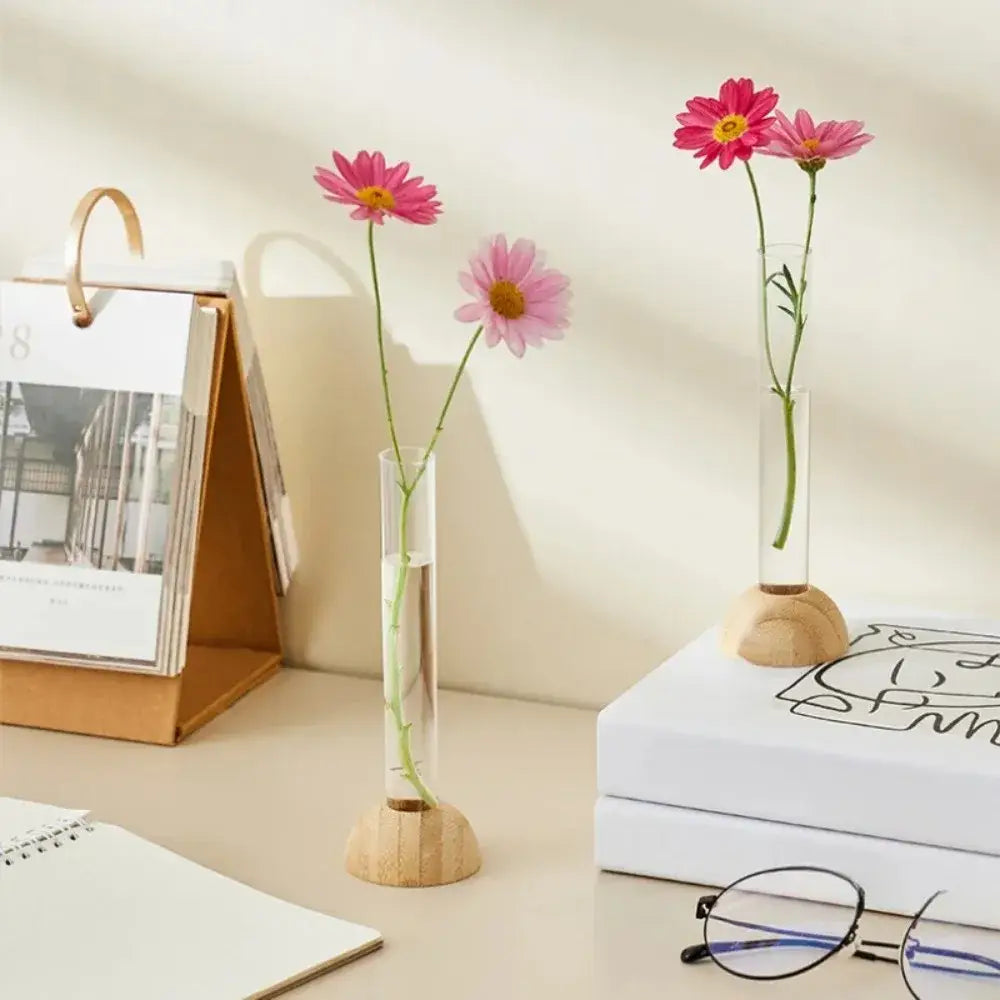 Decorbites™ clear vase with bamboo base holding pink daisies in a hydroponic vase tabletop decoration