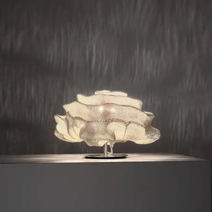A decorbites cloud chandelier featuring a delicate translucent white petal design with a metallic base for bedroom use