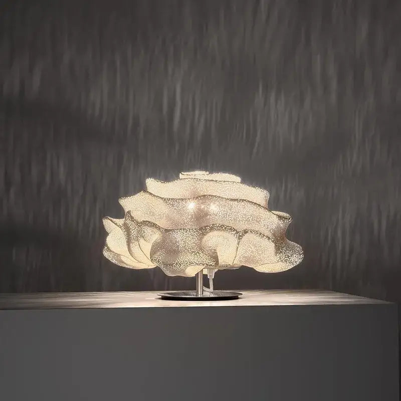 A decorbites cloud chandelier featuring a delicate translucent white petal design with a metallic base for bedroom use