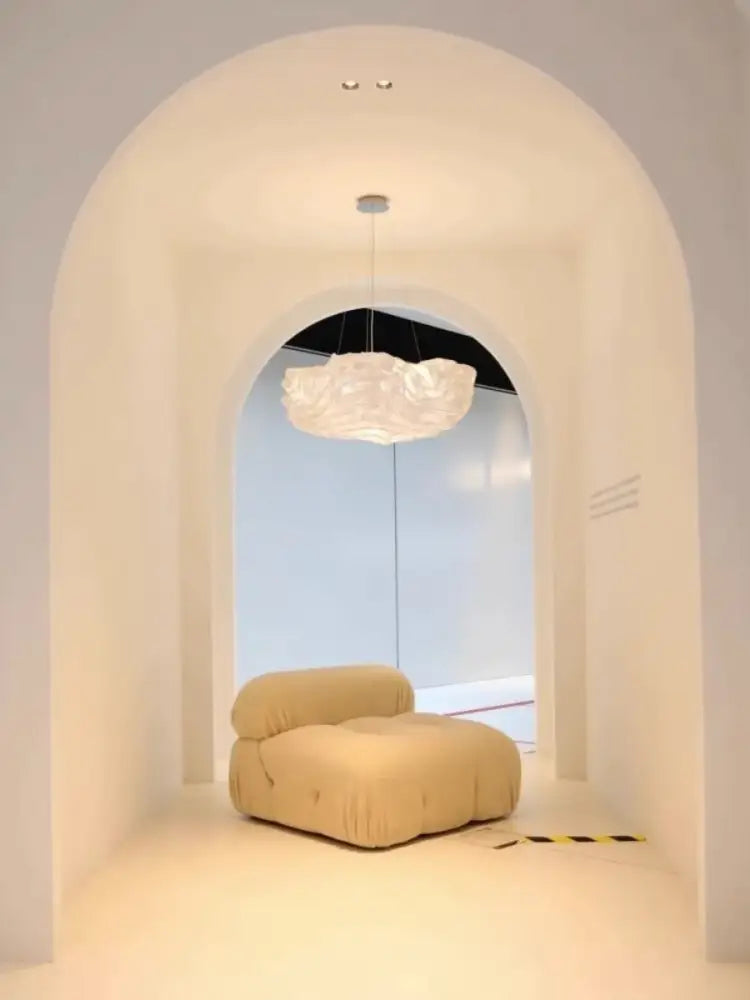Cream-colored plush cushioned lounge chair with soft fabric upholstery complementing decorbites cloud chandelier bedroom light