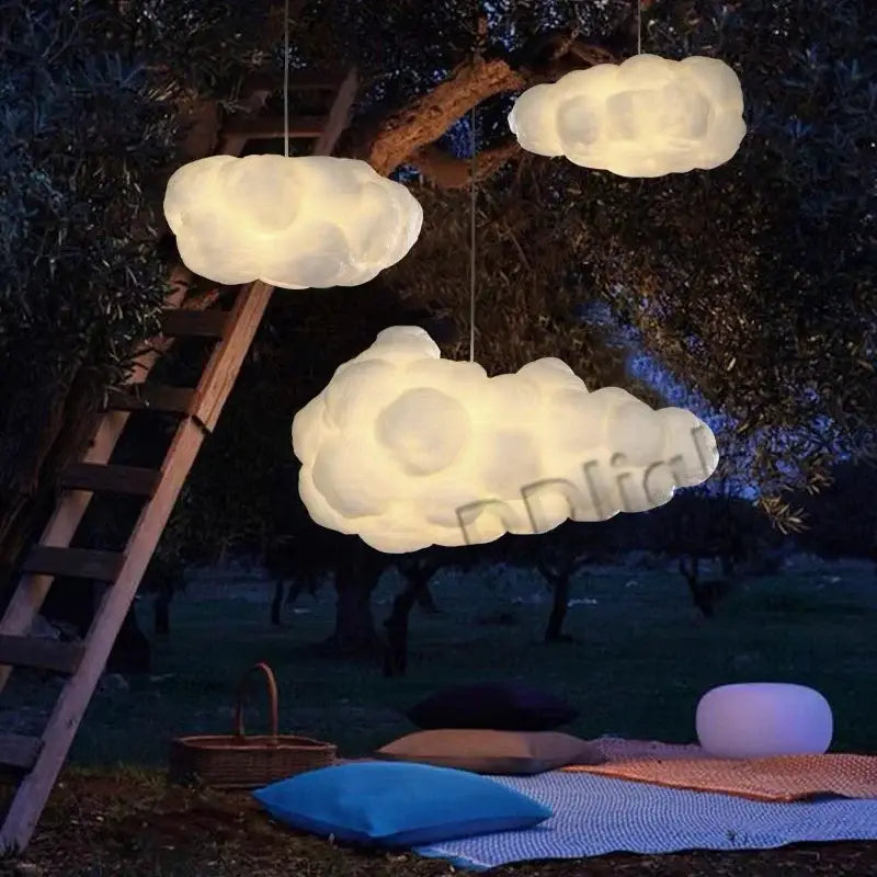 Three glowing white cotton decorbites cloud chandelier pendant lights hanging against a dark outdoor backdrop