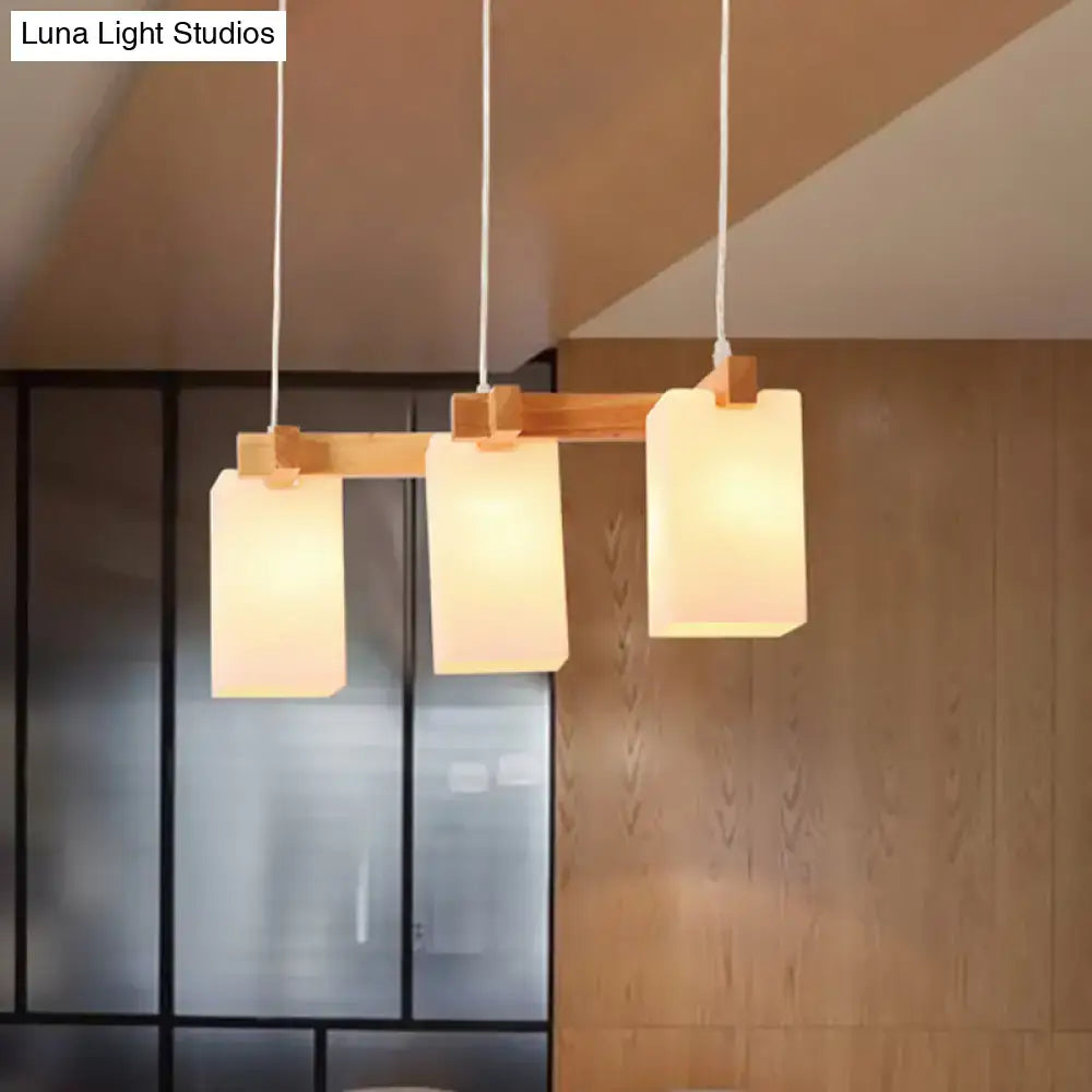 DecorBites cluster pendant kitchen lamp with three white glass shades in modern design and natural wood bar suspension