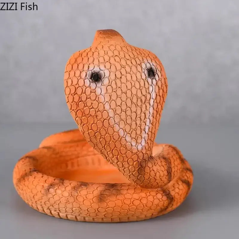 Orange resin decorbites cobra ashtray with textured scales and black eye details designed as a smoking accessory