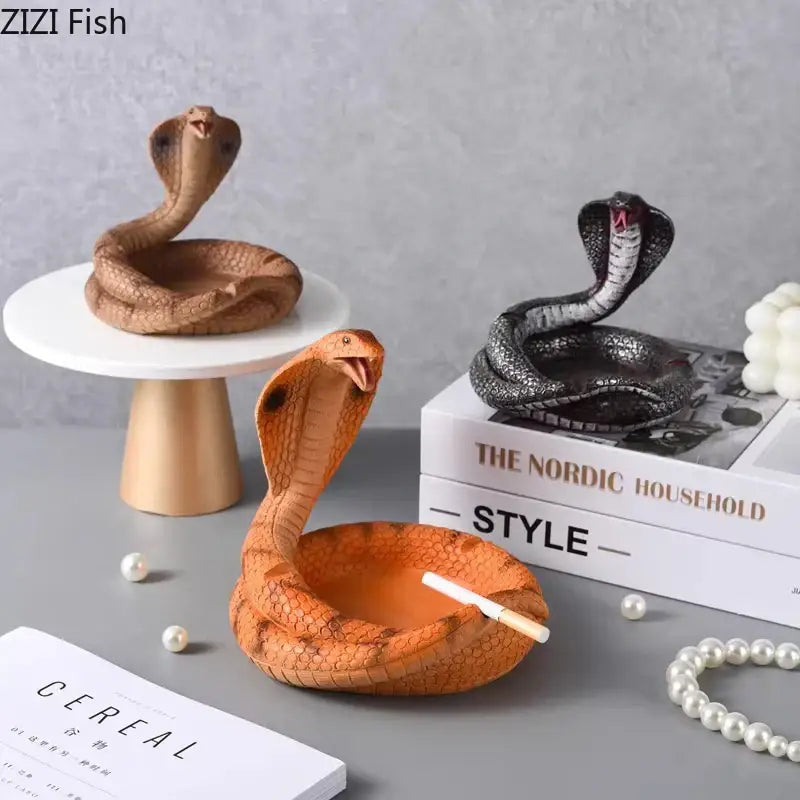Orange cobra-shaped decorbites cobra ashtray made of resin with textured scales and a cigarette inside for office use