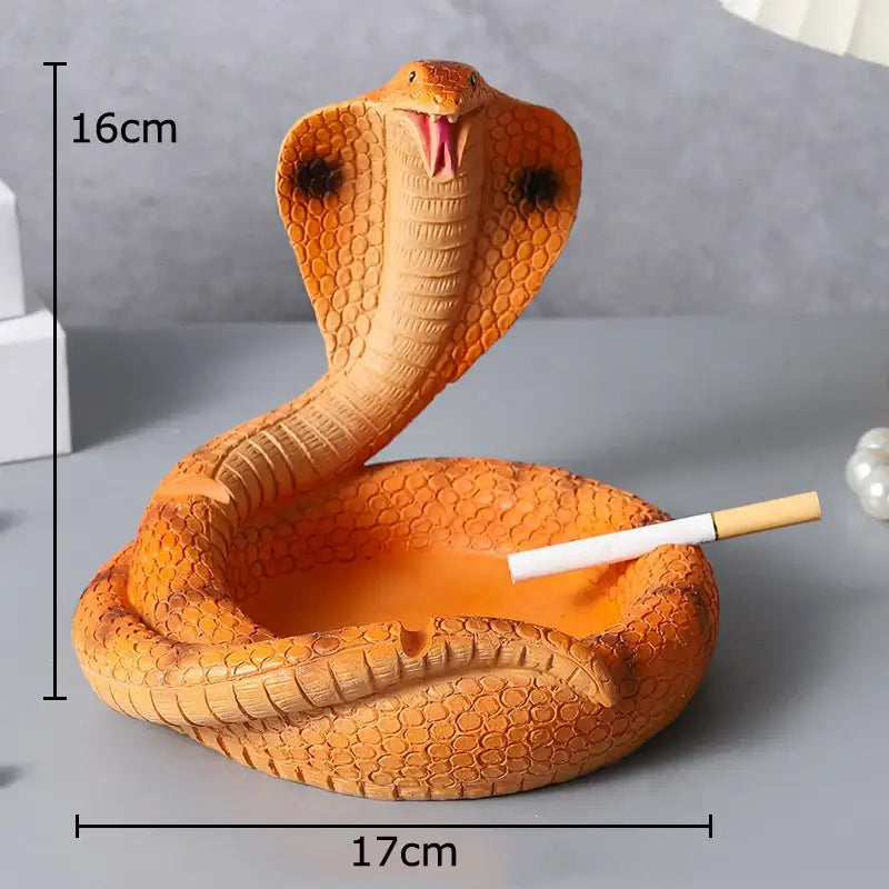 Orange resin decorbites cobra ashtray with detailed scales and raised hood featuring open mouth design for office use
