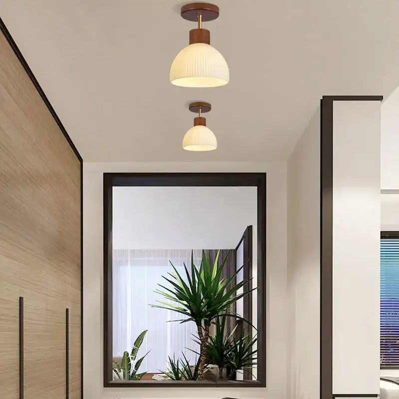 Two warm-toned dome-shaped ceiling chandelier lights with wooden fixtures and frosted glass by decorbites coco wood