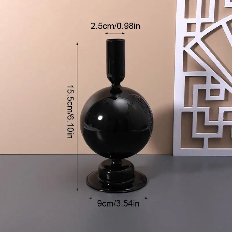 Black glossy glass vase with spherical body and narrow neck for stylish home decor by DecorBites™