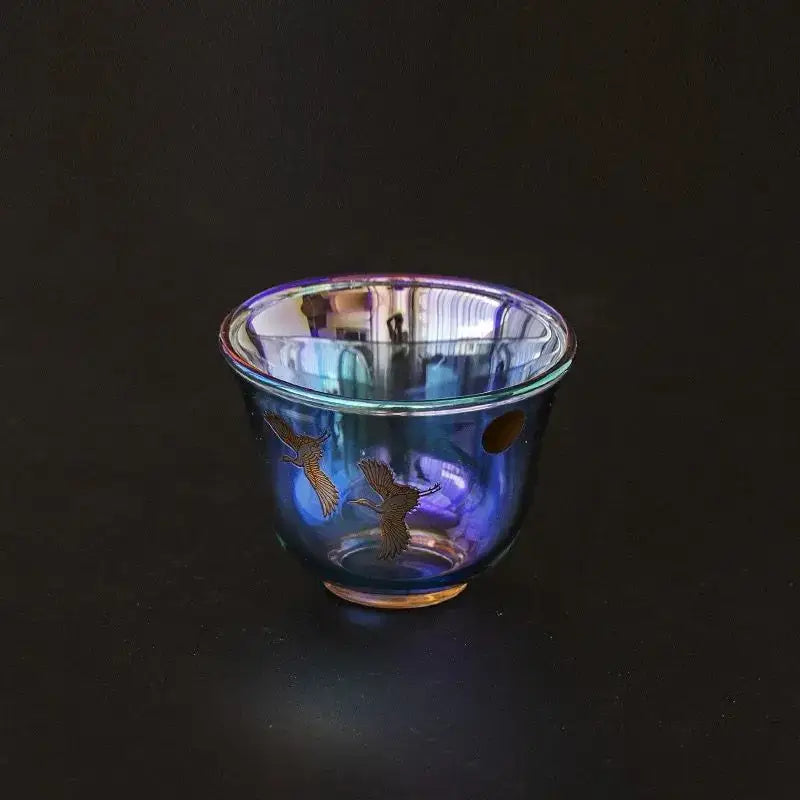 Iridescent blue glass teacup with delicate gold crane illustrations from decorbites colorful enamel glass collection