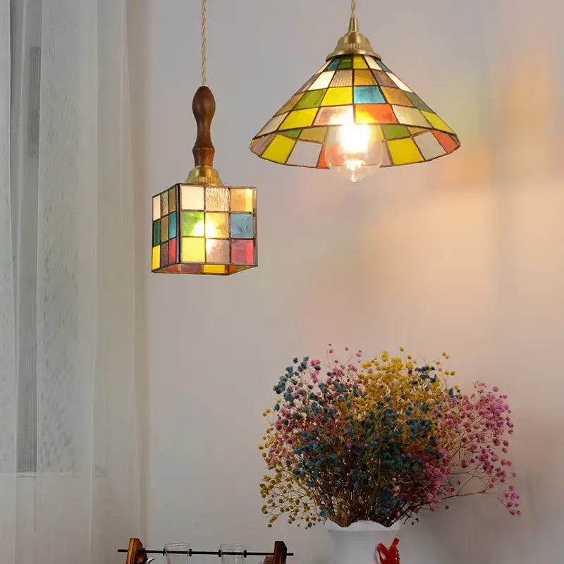 Two colorful glass magic pendant lights by decorbites featuring vibrant yellow green blue red and orange panels in brass frames