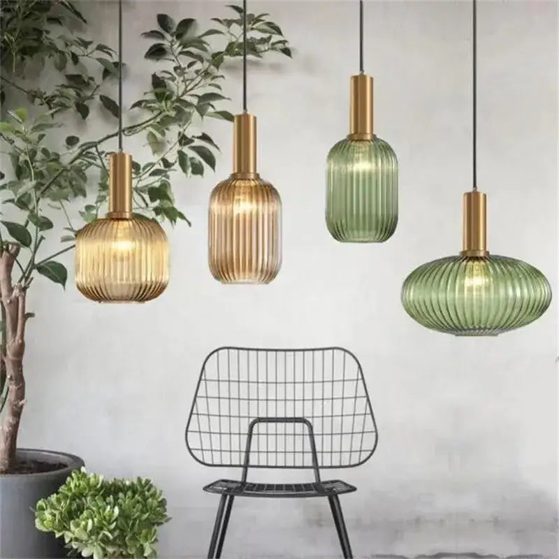 Four DecorBites™ colorful glass pendant lights with ribbed gold and green shades and brass-finished stems for retro style
