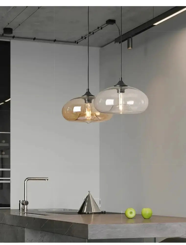 Two decorbites™ colorful led glass pendant lights with frosted shades and exposed filament bulbs for restaurant use