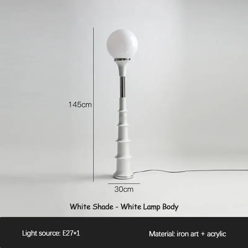 A sleek white decorbites colorful memphis floor lamp with a spherical glass shade and tiered acrylic base crafted from iron art and acrylic