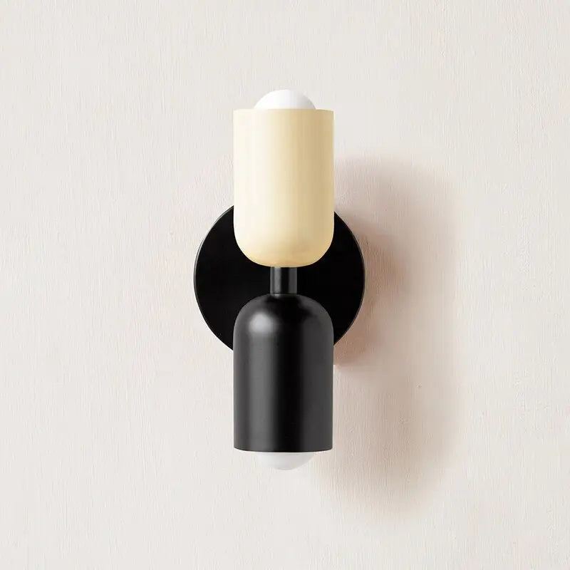 Cream-colored glass shade modern wall sconce with a black base and circular wall mount by decorbites