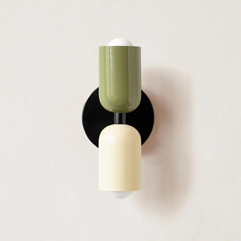 Modern wall sconce decorbites with a matte olive green and cream glass shade on a black circular base