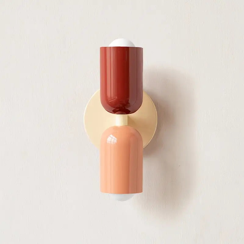 DecorBites™ colorful modern wall sconce with a glossy terracotta and peach glass shade on a cream backplate