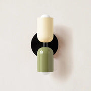 Modern wall sconce decorbites with a matte olive green lower cylinder glass shade and creamy off-white upper cylinder design