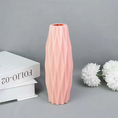 A sleek blush-pink modern flower vase with geometric facets and copper-toned rim by decorbites colorful plastic flower vase