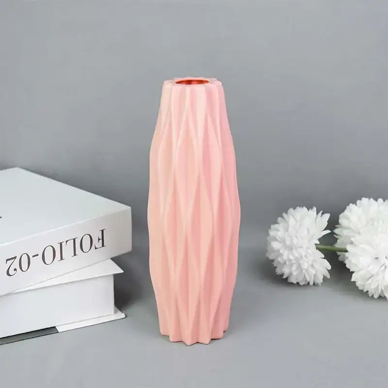 A sleek blush-pink modern flower vase with geometric facets and copper-toned rim by decorbites colorful plastic flower vase
