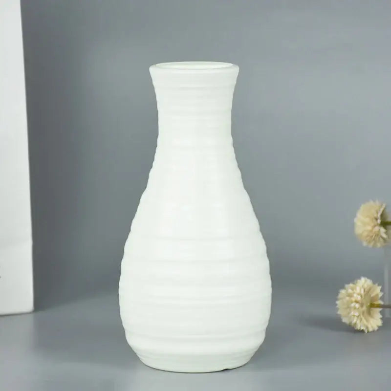 A sleek white ceramic flower vase with subtle ridges and a gently flared neck from decorbites colorful plastic flower collection