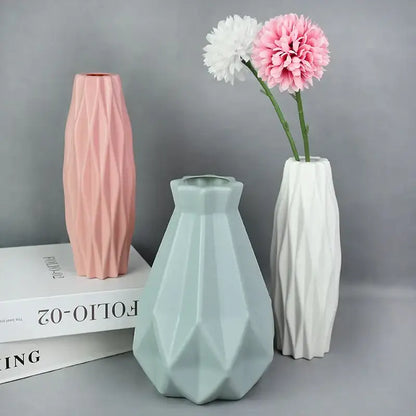 Three geometrically faceted pastel pink mint green and white colorful plastic flower vases for modern home décor